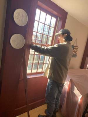 Tyler LiBrizzi finishes installation of a restored window